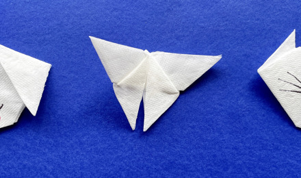 Enfants confectionnant des origami en papier coloré dans la chambre