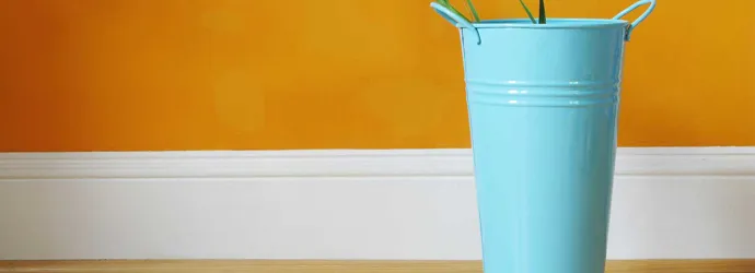 Plinthe blanche séparant un plancher en bois et un mur orange