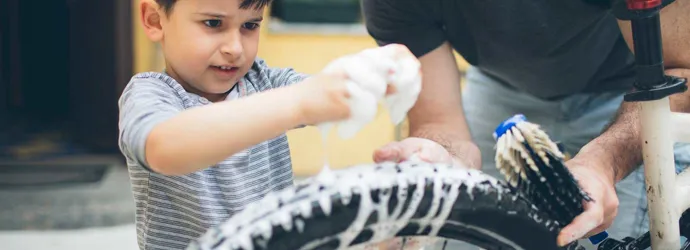 Vader en zoon maken een fiets schoon