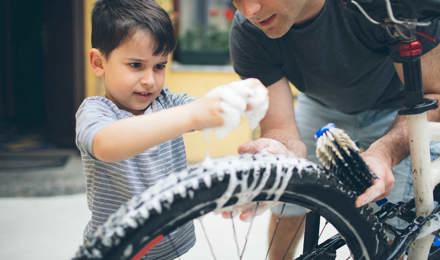 Vader en zoon maken een fiets schoon