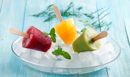 Drie fruitijsjes op een plek bedekt met ijsblokjes