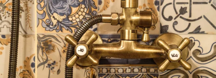 Robinet de douche en laiton sur un fond en mosaïque