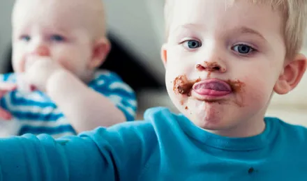 Un enfant avec des taches de chocolat partout sur son visage