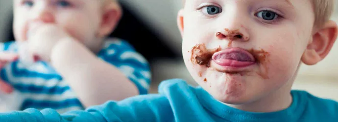 Un enfant avec des taches de chocolat partout sur son visage