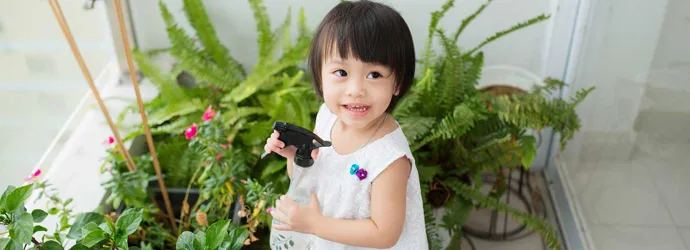 Une petite fille prend soin des plantes d'intérieur