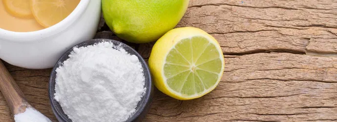 Eco produits de nettoyage tels que le citron, la chaux et le bicarbonate de soude sur une planche à découper en bois