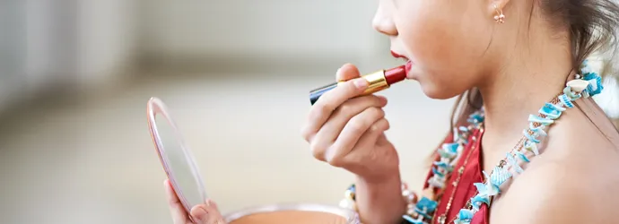 une jeune fille appliquant du rouge à lèvres